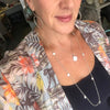 Person wearing a floral shirt with a necklace, indoors.
